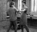 Barber and client greeting each other warmly inside a barbershop