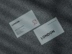Two-sided minimal grey barbershop staff business card template mockup showing shop logo front with QR code and services tagline reverse