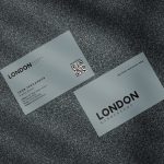 Two-sided minimal grey barbershop staff business card template mockup showing shop logo front with QR code and services tagline reverse