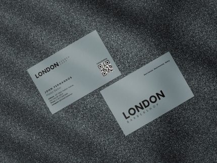 Two-sided minimal grey barbershop staff business card template mockup showing shop logo front with QR code and services tagline reverse