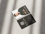 Double-sided solo barber name card template mockup showing full-face photo front and oversized QR booking code on minimal black reverse