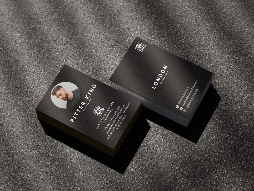 Double-sided minimal black barber business card template mockup showing shop branding front and barber photo with QR code reverse