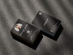 Double-sided minimal black barber business card template mockup showing shop branding front and barber photo with QR code reverse