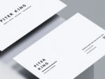Close-up of minimalist white barber business card template showing black typography, QR code placeholder and contact details