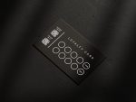 Barber handing a matte black reward card to a client after a haircut payment with the discount milestone reverse visible