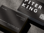 Close-up of bold black and white barber name card template showing large name typography, QR code and Men's Hair Beards descriptor