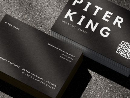 Close-up of bold black and white barber name card template showing large name typography, QR code and Men's Hair Beards descriptor
