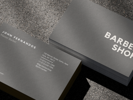 Close-up of ultra-minimal grey barbershop card template showing the single barbershop wordmark on the front face