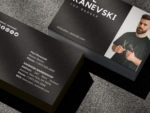 Close-up of black two-sided barber photo business card template showing social media icons and QR code on the reverse