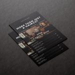 Printed A5 barbershop brochure template in minimal black design displayed on a dark marble surface