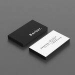 Black and white personal barber business card template showing bold BARBER text on front and contact details on back, flat lay mockup