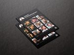 Printed A5 barber portfolio brochure template showing circular photo, work grid and QR code on a dark studio surface
