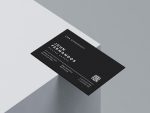 Back face of minimalist barber card template showing barber name, job title, QR booking code, phone number, address and social media handles