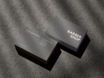 Two-sided ultra-minimal grey barbershop card mockup showing single wordmark front and full contact details reverse on concrete surface